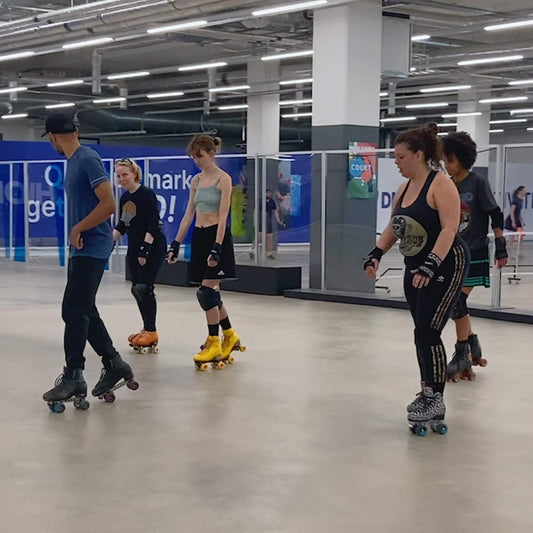 Group of skaters learning how to dance on roller skates at Mellow Moves Roller skate Foundations lesson in Decathlon Surrey Quays.