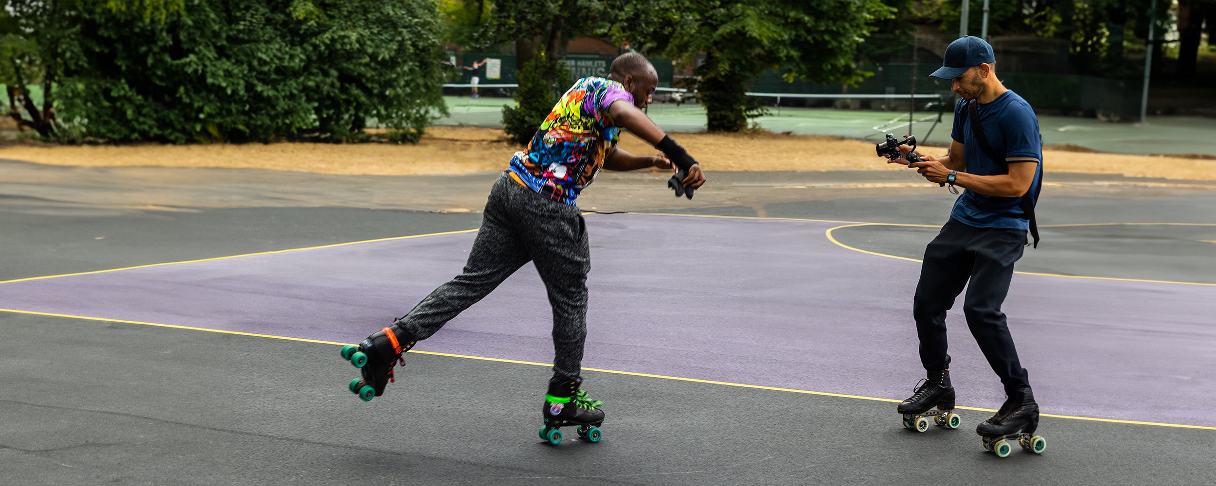 Roller skating filmmaker Mellow Moves filming Nana roller skating backwards at Bethnal Green Gardens during Roll On London.