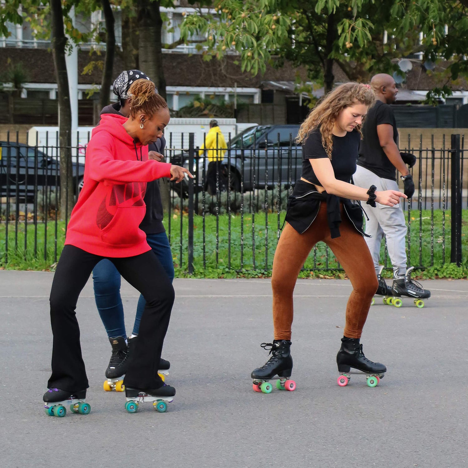 Two roller skaters side surfing during a roller skating class in Burgess Park South London.